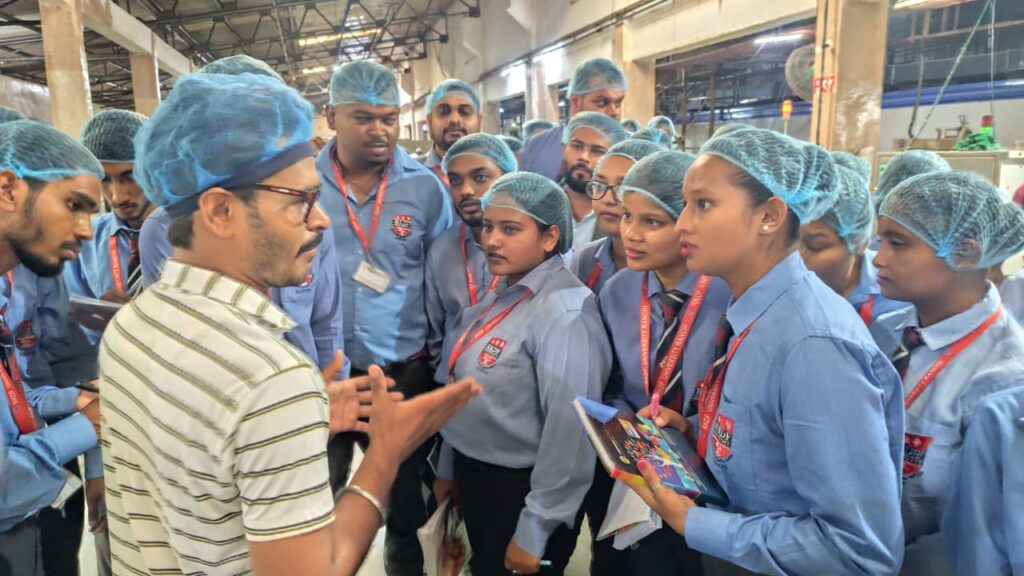 फैक्ट्री में बिस्किट निर्माण और ऑटोमैटिक पैकेजिंग लाइन को देखते आरकेडीएफ यूनिवर्सिटी के छात्र